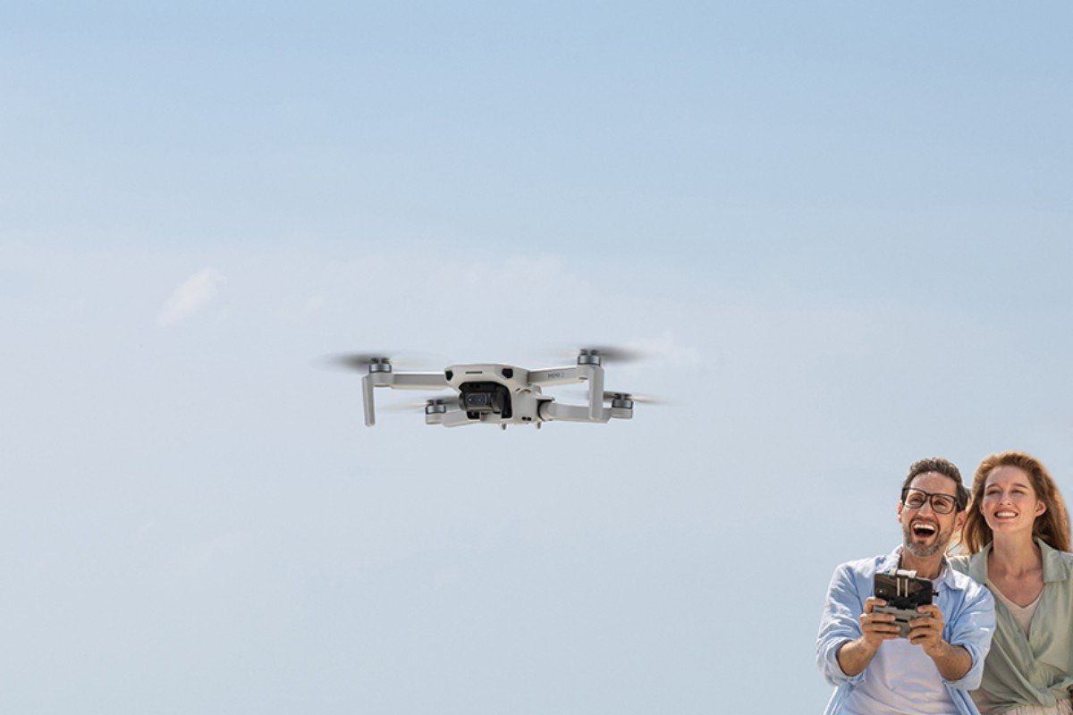 Dron DJI Mini 2 Fly More Combo Biało-szary widok na przód pod kątem, dron w trakcie lotu