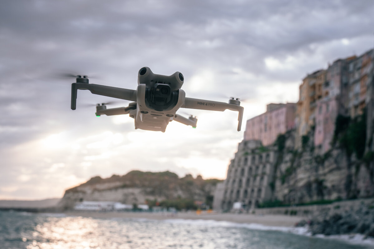 Dron DJI Mini 4 Pro (RC-N2) grafika przedstawiająca dron latający nad plażą