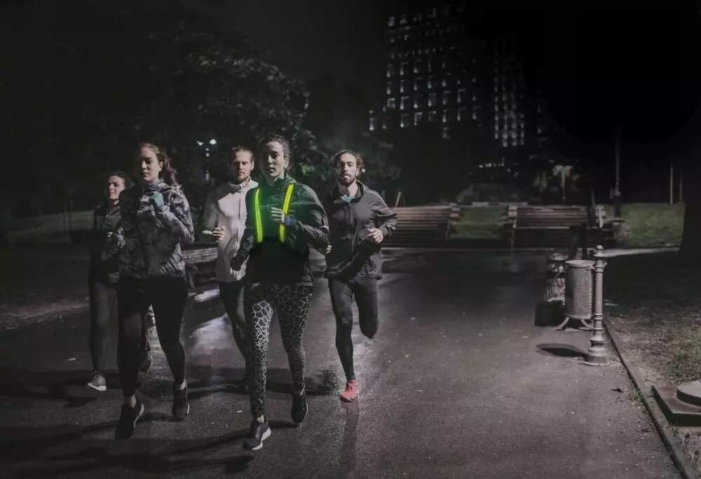 Kamizelka EasyPix StreetGlow S/M grafika przedstawia grupę biegaczy w nocy w tym kobietę w kamizelce