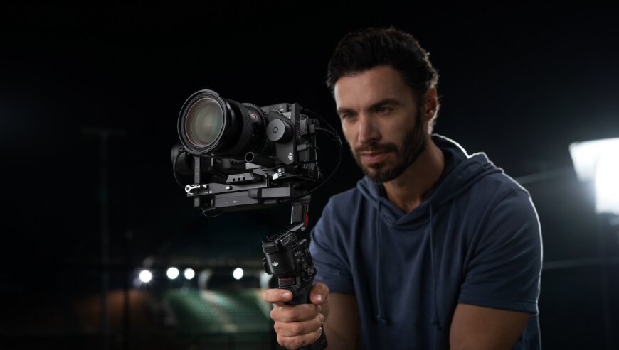 Stabilizator obrazu DJI RS 4 czarny widok na mężczyznę trzymającego w dłoni stabilizator z zamontowaną kamerą